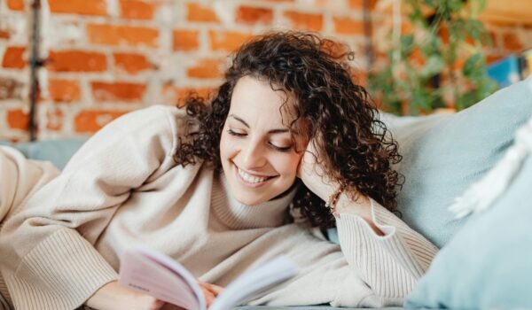 Mujer feliz disfrutando de los beneficios de leer novela romántica